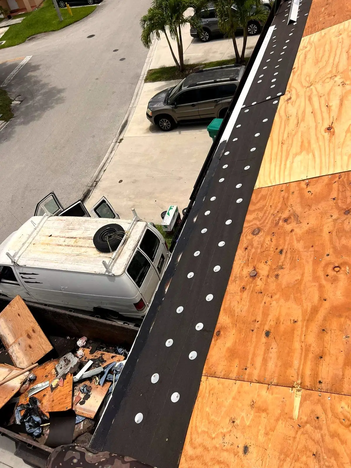 Roof edge dried in after a tear-off, with debris loaded in the truck below