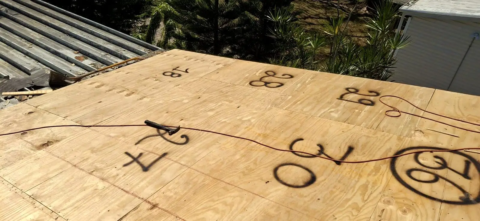 New plywood roof sheathing marked up during a deck repair